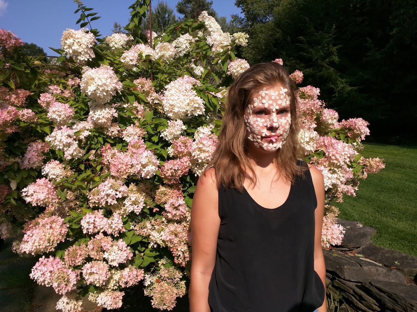 A participant framed by an abundant mass of pale pink flowers